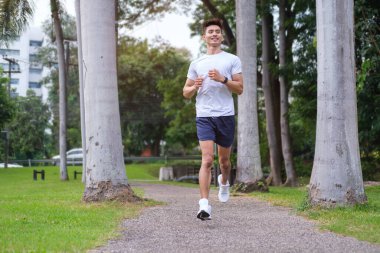 Sabahları parkta koşan aktif bir adamın tam boy fotoğrafı. Fitness, egzersiz ve sağlıklı yaşam tarzı konsepti.