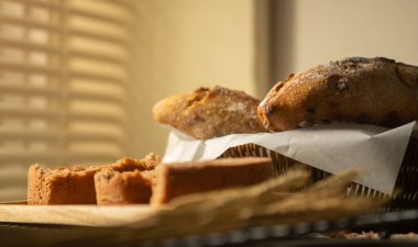 Ev yapımı bir somun geleneksel ekmek ve ahşap masada buğday taneli kulak..