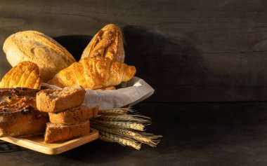 Siyah kırsal arka planda taze pişmiş ekmek çeşitleri. Metnin için boşluk kopyala.