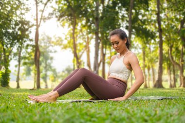 Spor giyim kuşağında, sabah parkında yoga yapan bin yıllık bir kadın. Yoga, pilates, spor, sağlıklı yaşam tarzı konsepti.