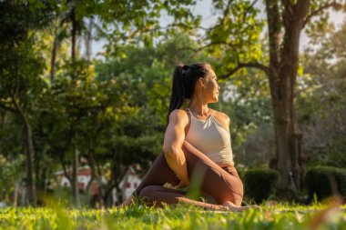 Huzurlu kadın doğanın arka planında yoga yapıyor. Yoga, pilates, sağlıklı yaşam tarzı konsepti.