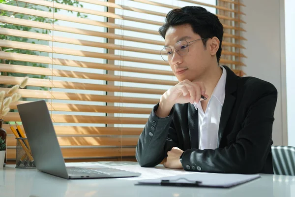 专心致志的商人坐在办公室时 在笔记本电脑上分析财务数据 — 图库照片