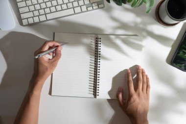 Not defterine kalem yazan adamın genel görünümü, organizatör kişisel kağıt planlayıcı içinde yeni randevu bilgileri planlama.
