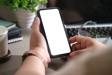 Çalışan masanın üzerinde akıllı telefonları tutan kadınların yakın görüntüsü. Reklam tasarımınız için boş ekran.