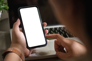 Çalışma masasında cep telefonu kullanan bir kadın. Reklam tasarımınız için boş ekranı kapatın.