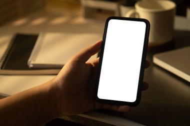 Akıllı telefonun el ele tutuşunun yakın görüntüsü. Reklam tasarımınız için beyaz boş ekran.