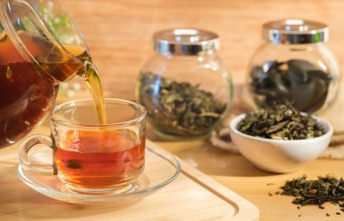 Çaydanlıktan bardağa siyah çay dökülüyor..