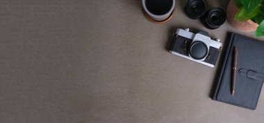 Kamera, defter ve kahve fincanı gri masada. Reklam metnin veya bilgi içeriğin için alanı kopyala.