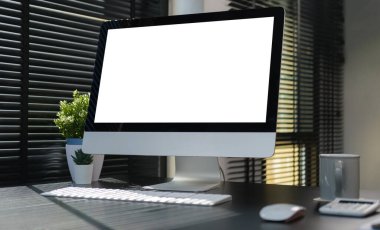 Modern ofis masasında kablosuz klavyesi, kakülatörü ve kahve fincanı olan boş bir bilgisayar masaüstü..