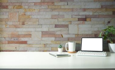 Digital tablet, notebook, houseplant and coffee cup on white table. copy space for product display and presentation. 
