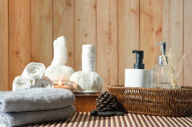 Beautiful spa composition on white table with, spa herbal ball, towels and burning candles.