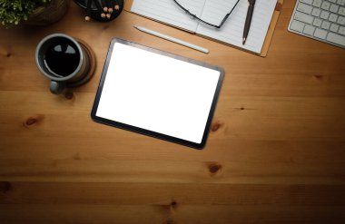 Boş ekran, kahve fincanı, not defteri ve klavyeli dijital tablet..