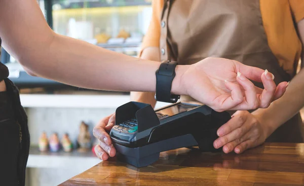 stock image Female customer using smartwatch for contactless payment for her order in cafe. Non-cash payment concept.