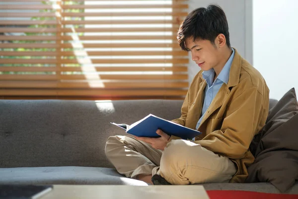 Calm Asian Man Reading Book Cozy Bright Living Room Sunlight — Stock Photo, Image