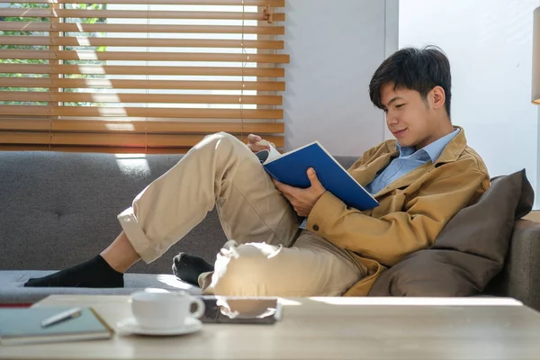 Peaceful Asian Man Lying Comfortable Sofa Reading Book — 스톡 사진