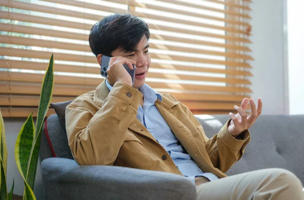 Genç Adam Oturma Odasında Oturuyor Akıllı Telefondan Konuşuyor — Stok fotoğraf
