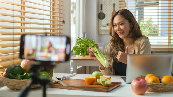 stock image Professional female nutritionist talking about healthy diet and recording video blog  on a smart phone.