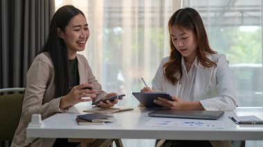 Modern ofiste pazarlama planını tartışan mutlu genç girişimciler veya ortak çalışma alanı