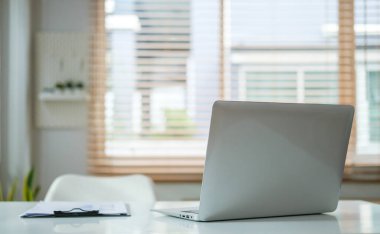 Laptop bilgisayar ve pano modern ofis içi çalışma masasında..