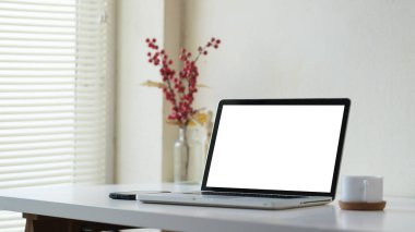 Bilgisayarlı akıllı telefon ve beyaz masada bir fincan kahve olan modern işyeri..