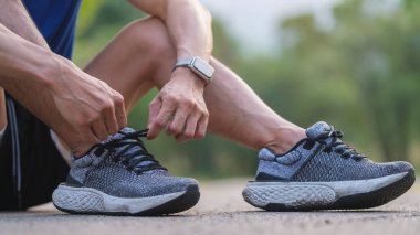 Spor ayakkabısı bağlayan, spor yapmaya hazırlanan ya da dışarıda antrenman yapan fitness adamına yakın çekim. Sağlık ve spor konsepti.