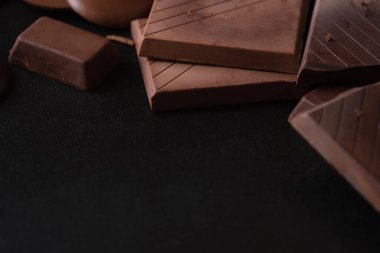 Arkaplanda siyah çikolata parçaları ve metin için boş alan.