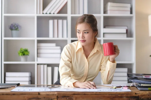Młoda Bizneswoman Pijąca Kawę Analizująca Wyniki Pracy Odwalająca Papierkową Robotę — Zdjęcie stockowe