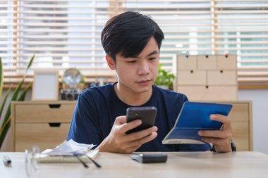 Milenyum adamı akıllı telefondan ev faturalarını ödüyor, para tasarrufu, yatırım ve gider kavramını planlıyor.