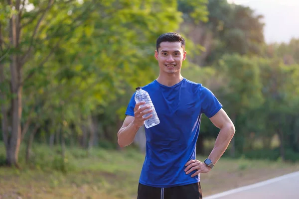 Portret Młodego Azjatyckiego Sportowca Trzymającego Butelkę Wody Odpoczywającego Bieganiu Parku — Zdjęcie stockowe