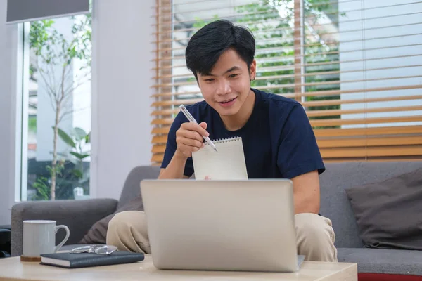 Young Asian Man Working Home Using Laptop Couch Bright Living — 스톡 사진