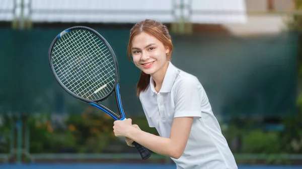 阳光灿烂的夏日 年轻女子一边在球场上打网球 一边微笑着等待接球 — 图库照片