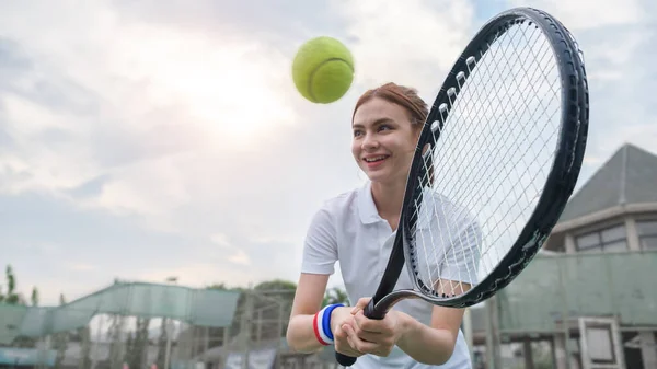 青い空にラケットでボールを打つ美しい若い女性 スポーツ トレーニング 健康的なライフスタイルのコンセプト — ストック写真