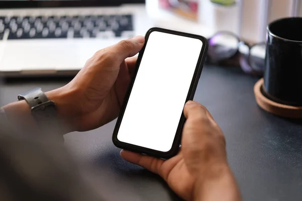 stock image Close up view man holding smart phone with empty display.