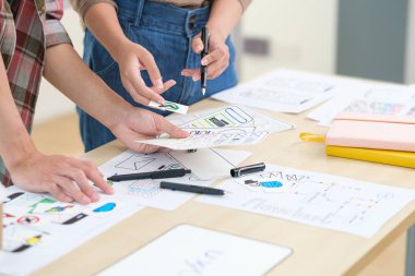 Two web designers are working and designing user interface for website and application together.	