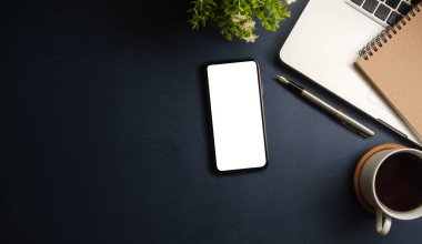 Not defteri, dizüstü bilgisayar ve kahve fincanı fare notlu üst görünüm ofis malzemeleri. Boş ekran cep telefonu ve masa başı çalışma alanı üzerindeki malzemeler ve kopyalama alanı..