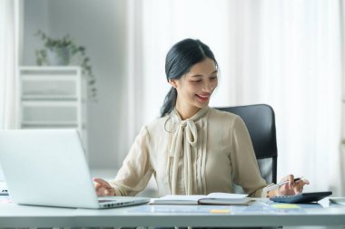 Modern iş yerinde dizüstü bilgisayarla çalışan güzel bir iş kadını..