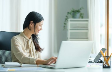 Ofisinde çalışırken tablet üzerinde çalışan mutlu genç kadının portresi..