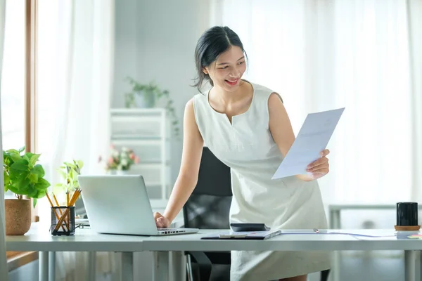 ラップトップコンピュータを使用した美しいアジアのビジネス女性とオフィスデスクで財務文書をチェック — ストック写真
