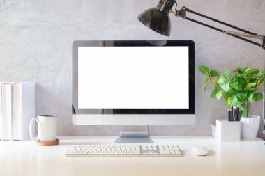 Ev içi ofis içi boş bilgisayar monitörü ve ofis malzemeleri beyaz masada..