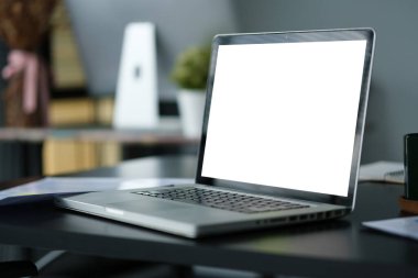 Laptop bilgisayarı ve siyah ahşap masada saksı bitkisi olan rahat bir iş yeri. Reklam tasarımınız için boş ekran.