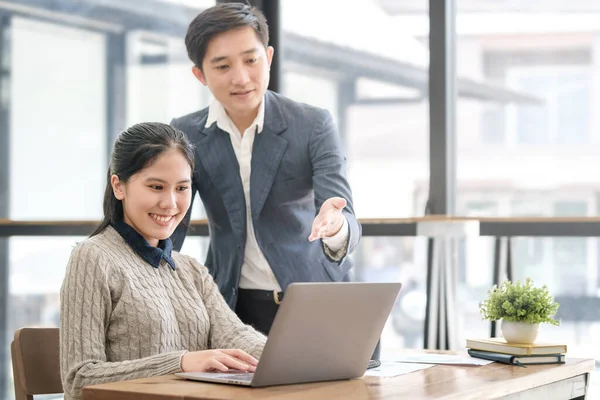 Dost canlısı iş adamları dizüstü bilgisayar kullanıyor, modern ofiste yeni bir proje üzerinde birlikte çalışıyorlar..