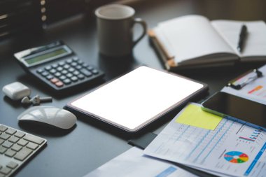 İş grafikleri, çizelgeler, dijital tablet ve hesap makinesi ofis masasında. Mali kalkınma, bankacılık hesabı ve istatistik.