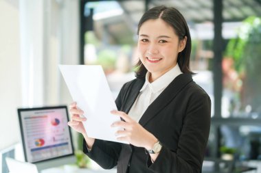 Milenyum kadın yöneticisinin portresi modern ofiste duruyor..