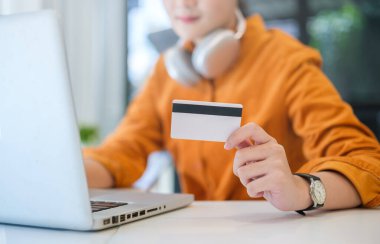 Woman holding credit card and using laptop computer. Online shopping, e-commerce, internet banking concept.	