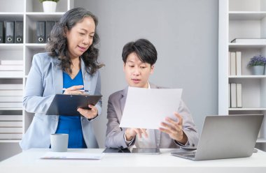 60 'ların pozitif orta yaşlı bayan yöneticisi genç işadamıyla yeni bir strateji planlıyor.