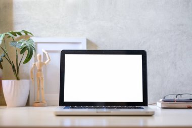 Dizüstü bilgisayar, kahve fincanı, saksı çiçeği ve yaratıcı iş yerindeki resim çerçevesi. Reklam metniniz için boş ekran.