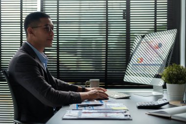 Professional businessman using computer and analyzing statistics data at office.	