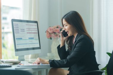 Güzel bir iş kadını cep telefonuyla keyifli bir konuşma yapıyor..