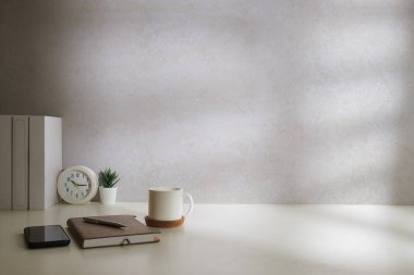 Kitapları, çalar saati ve beyaz masasında saksısı olan en az iş yeri..