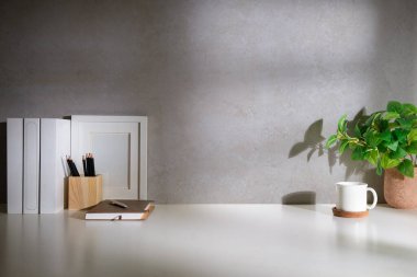 İçişleri Bakanlığı. Çiçek, kahve fincanı, kitaplar ve kalem tutacağı beyaz masada..